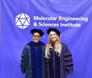 Al Nelson and Gökçe posing in front of a MolES sign. 