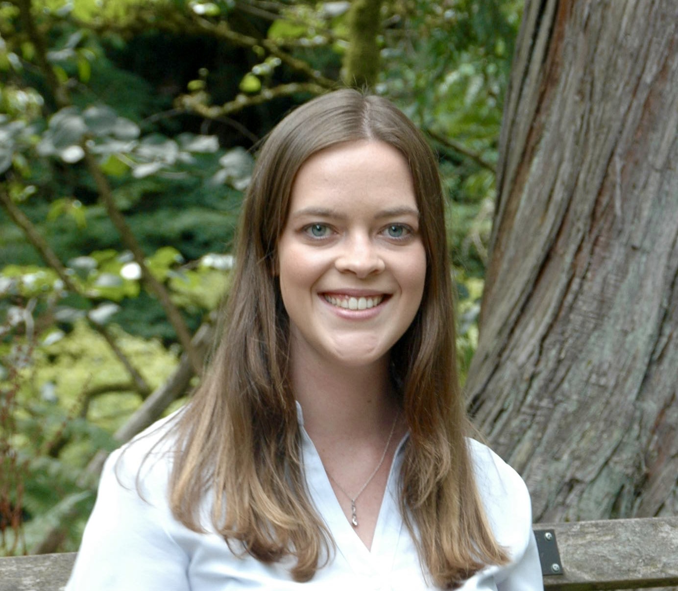 Headshot of Anika outside by the trunk of a tree